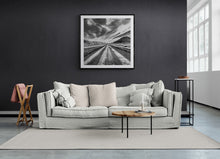 Load image into Gallery viewer, Framed Long Straight black and white landscape print displayed above a neutral sofa.