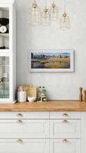 Load image into Gallery viewer, Reflections in Castle Hill Pond beneath the limestone formations of Kura Tāwhiti, framed in white in a modern kitchen setting