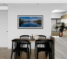 Load image into Gallery viewer, Lake Brunner reflecting the sky and surrounding mountains at Moana, fine art print framed in black with modern interior