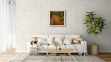 Load image into Gallery viewer, Milford Track framed art print depicting a rustic wooden pathway winding through a lush green forest with orange-brown ground, displayed on a light gray wall above a white sofa in a modern living room setting.