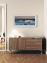 Load image into Gallery viewer, Waves at Greymouth Breakwater photograph by Stewart Nimmo framed in white hanging about a timber cabinet