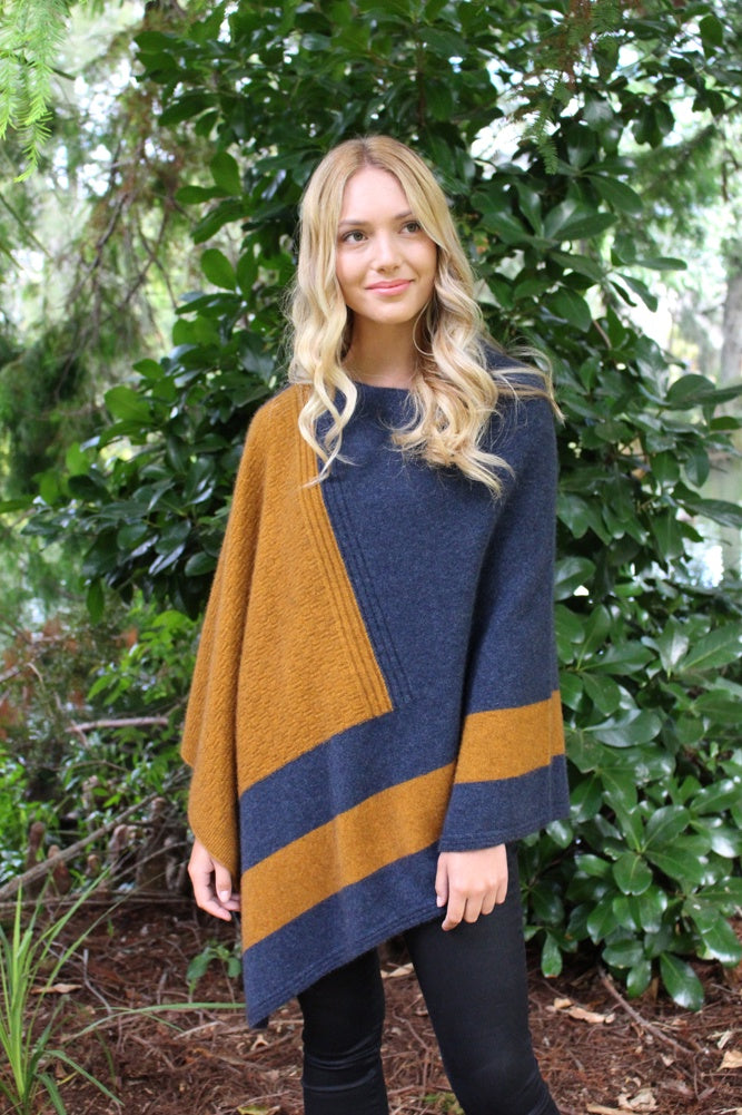 Asymmetrical possum merino poncho with geometric pattern in contrast colour. Textured knit structure feature in contrast panel. Lothlorian. Made in New Zealand. Gold